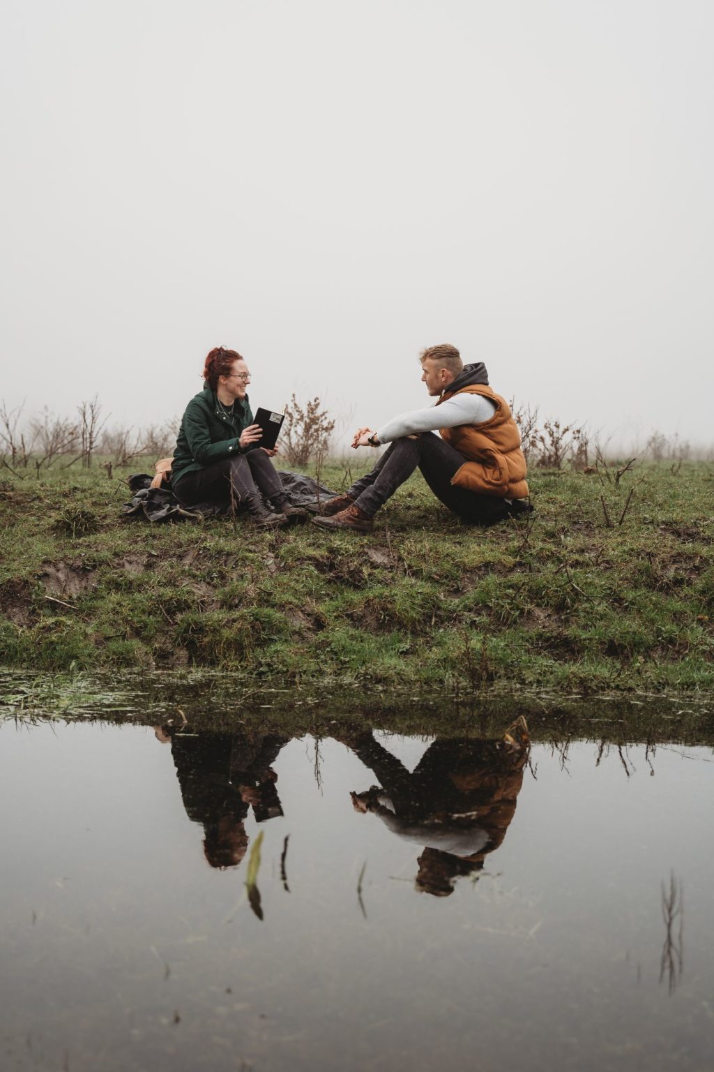 Jonathan Bouter en een cliënt zitten samen in het gras aan het water