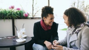 Twee vrouwen in gesprek aan een cafetafel