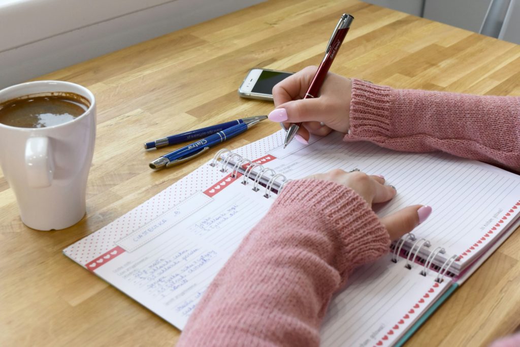 Schrijven in een notitieboek met een kop koffie