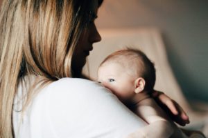 Moeder houdt haar baby dicht tegen zich aan