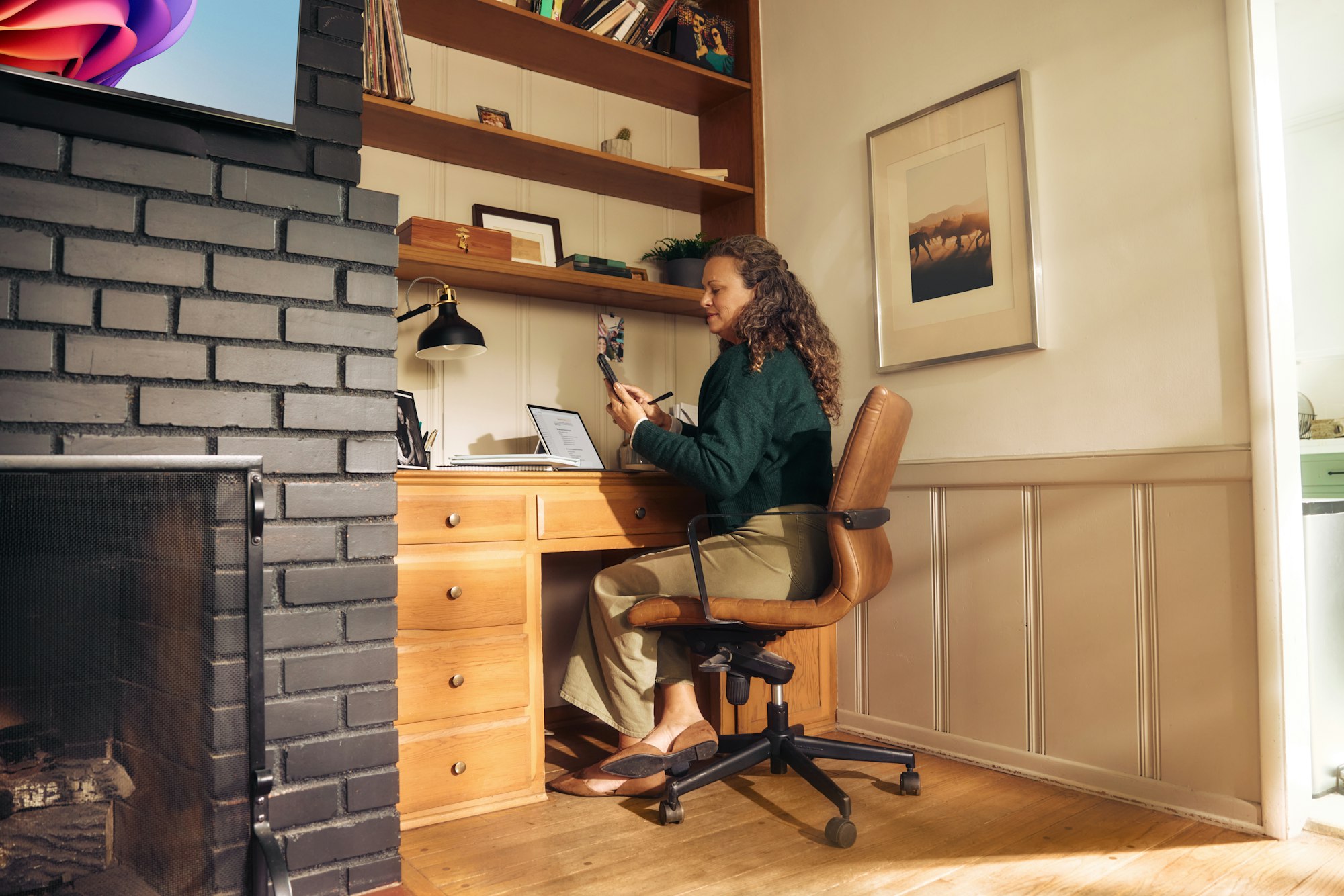 Vrouw werkt aan een bureau in een lichte kamer bij het raam