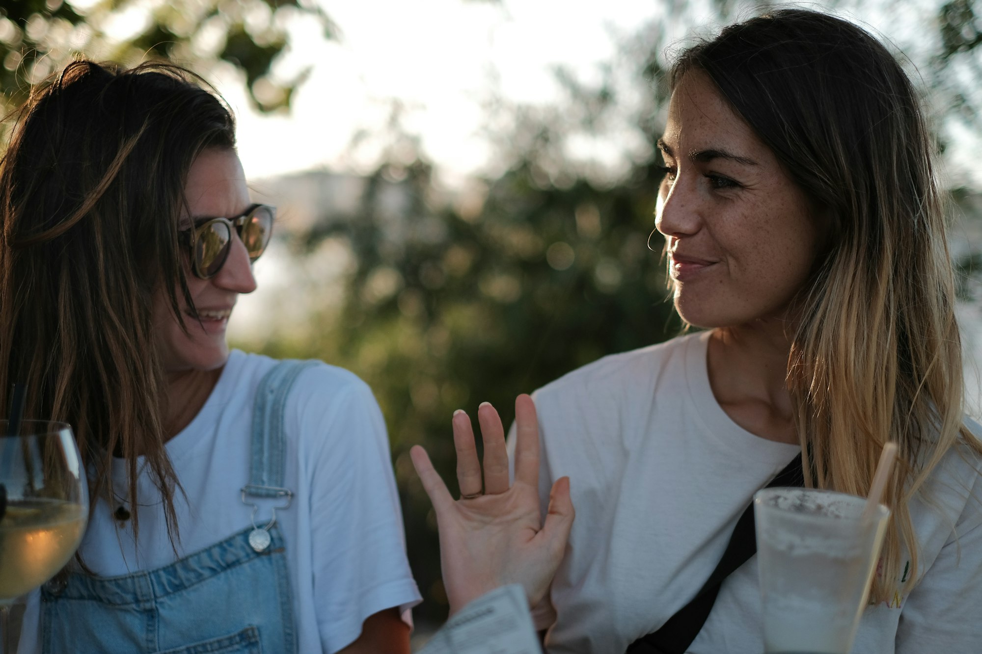 Twee vrouwen in gesprek buiten in warm middaglicht