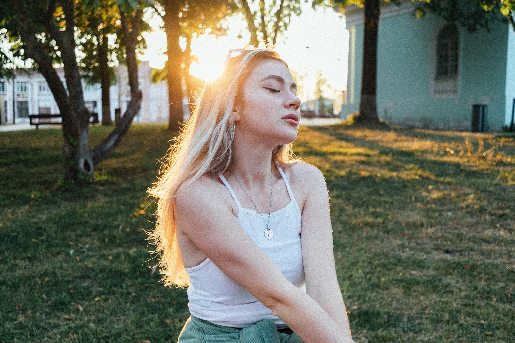 Vrouw met gesloten ogen in het zonlicht in een park