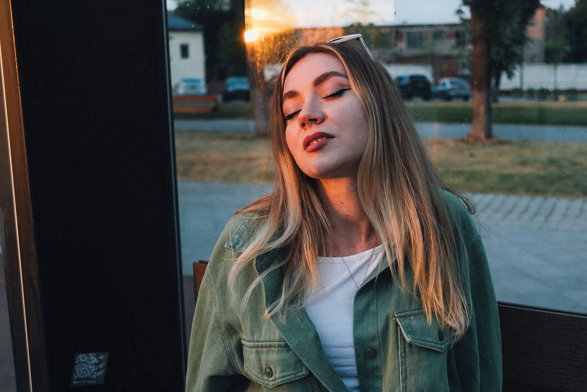 Vrouw met gesloten ogen in het late zonlicht op een plein