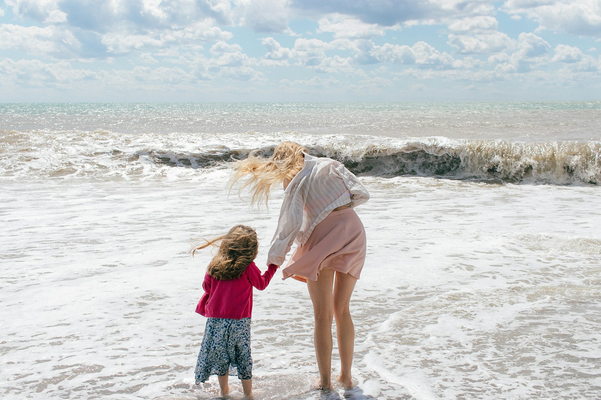 Moeder en dochter spelen lachend in de golven