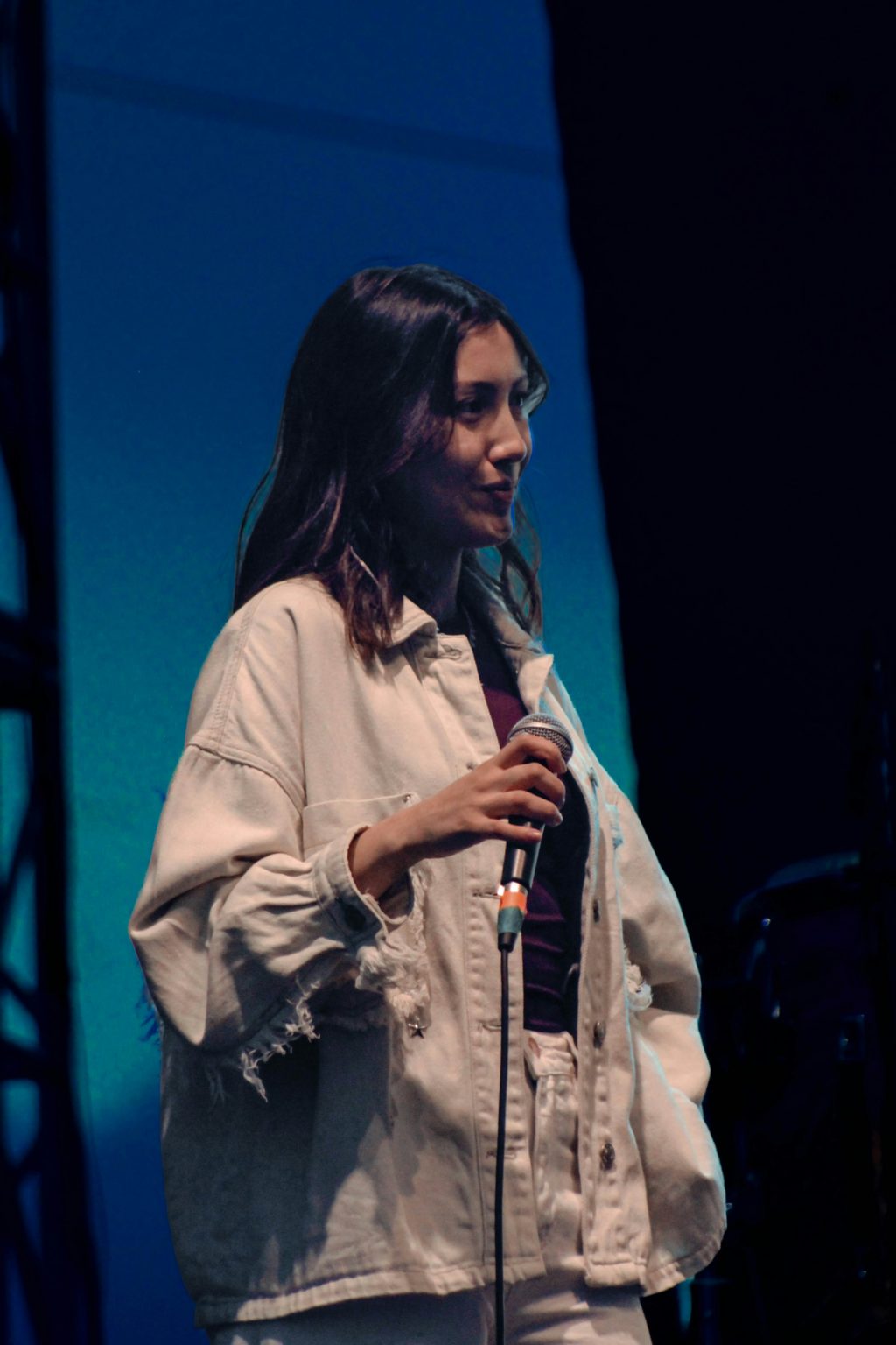 Vrouw met een microfoon in haar hand op een podium