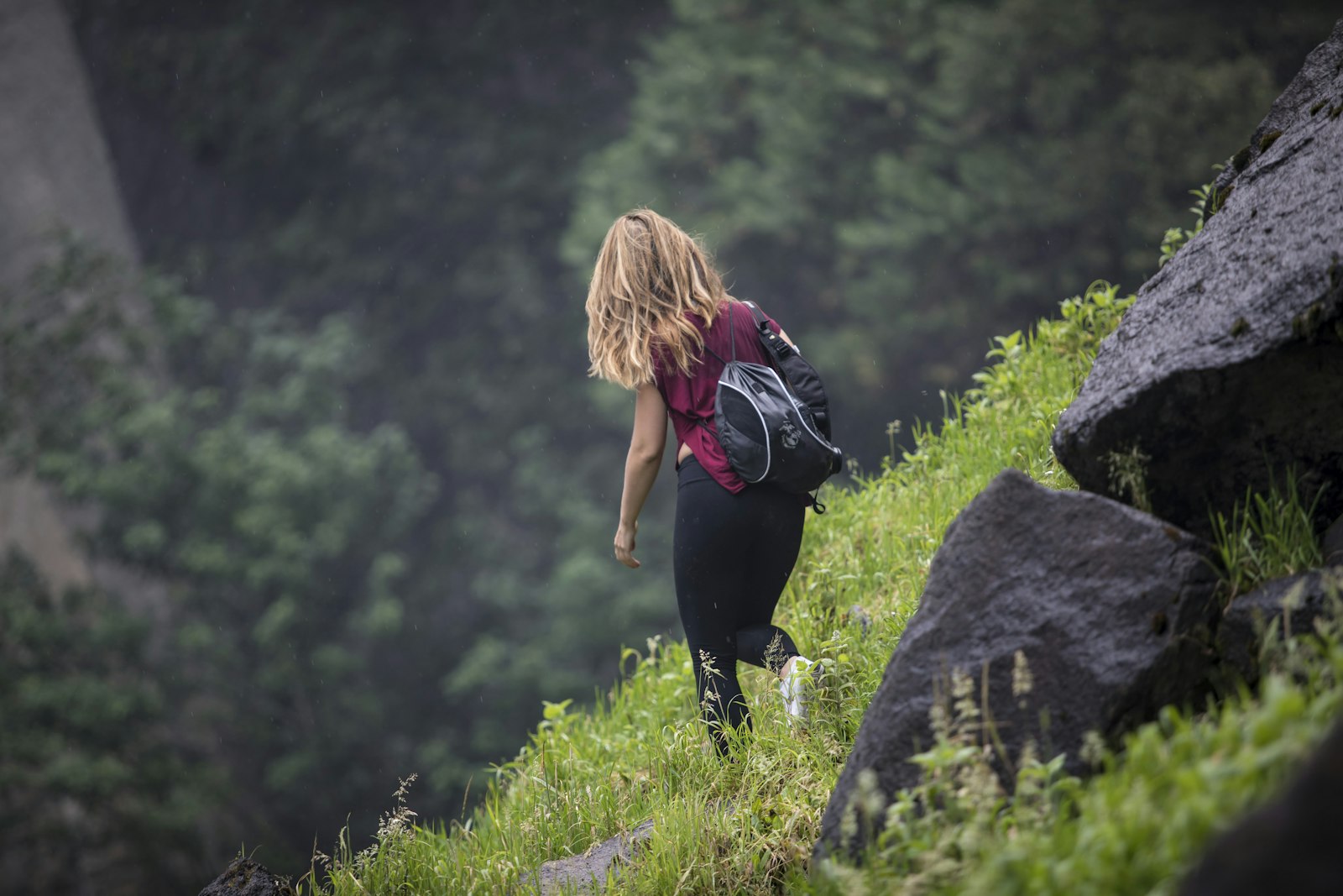 Vrouw klimt een steile groene helling op