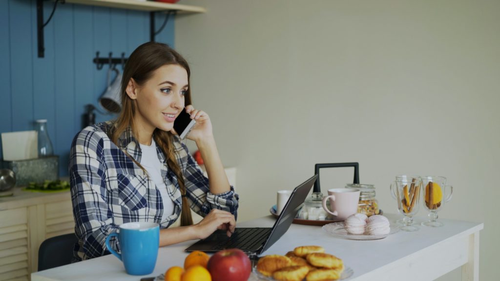 Vrouw belt aan de keukentafel