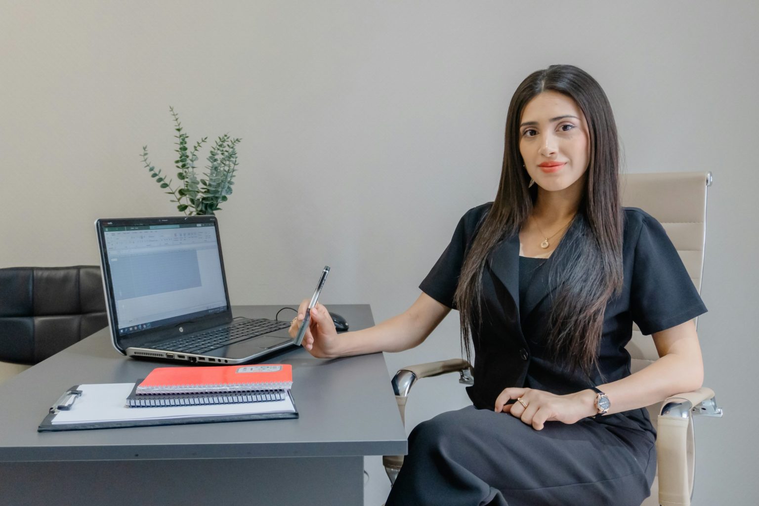 Vrouw zit rechtop en vastberaden aan het bureau in haar eigen werkplek