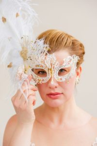 Vrouw houdt een wit masker voor haar gezicht en kijkt erdoorheen
