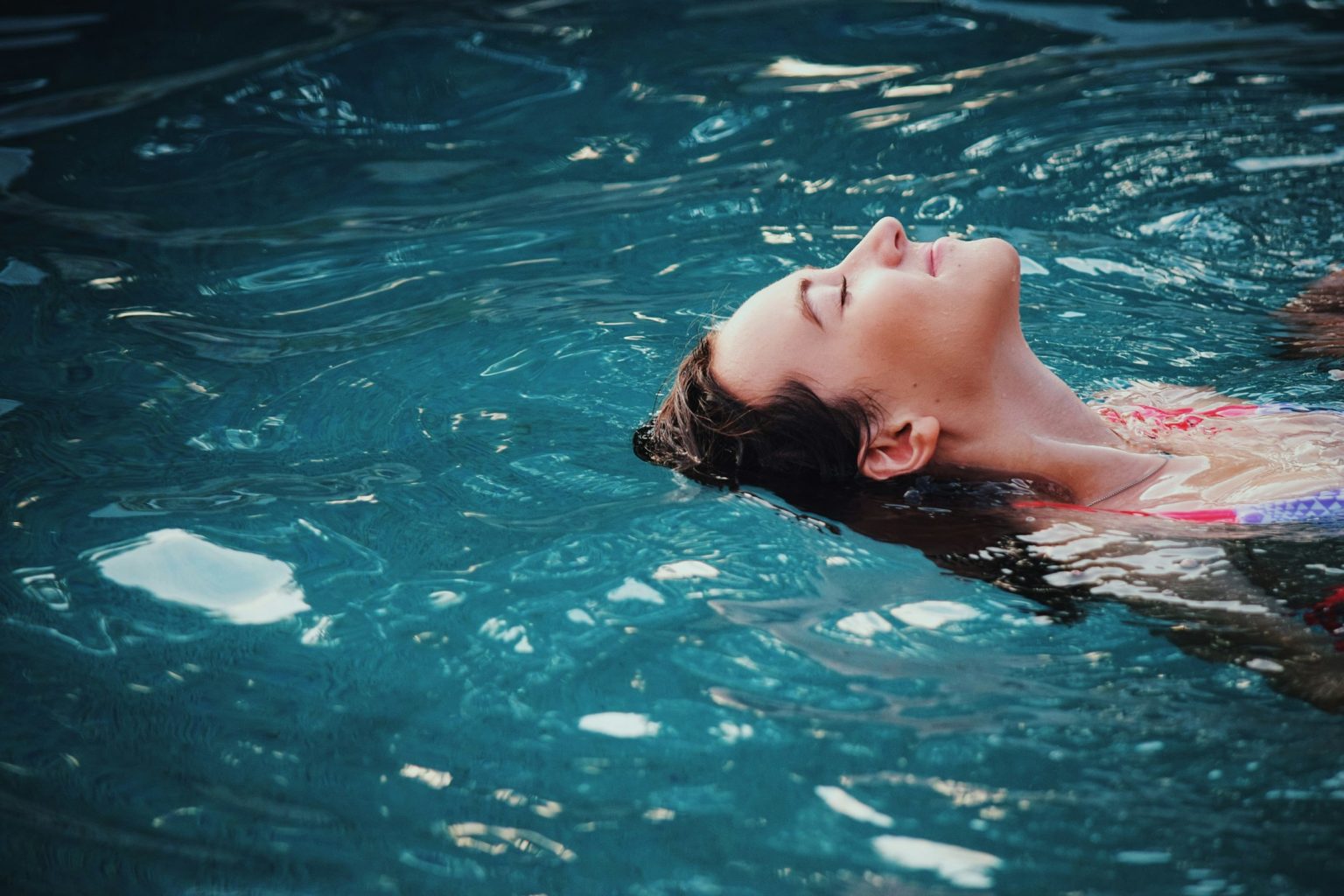 Vrouw drijft ontspannen op haar rug in het water