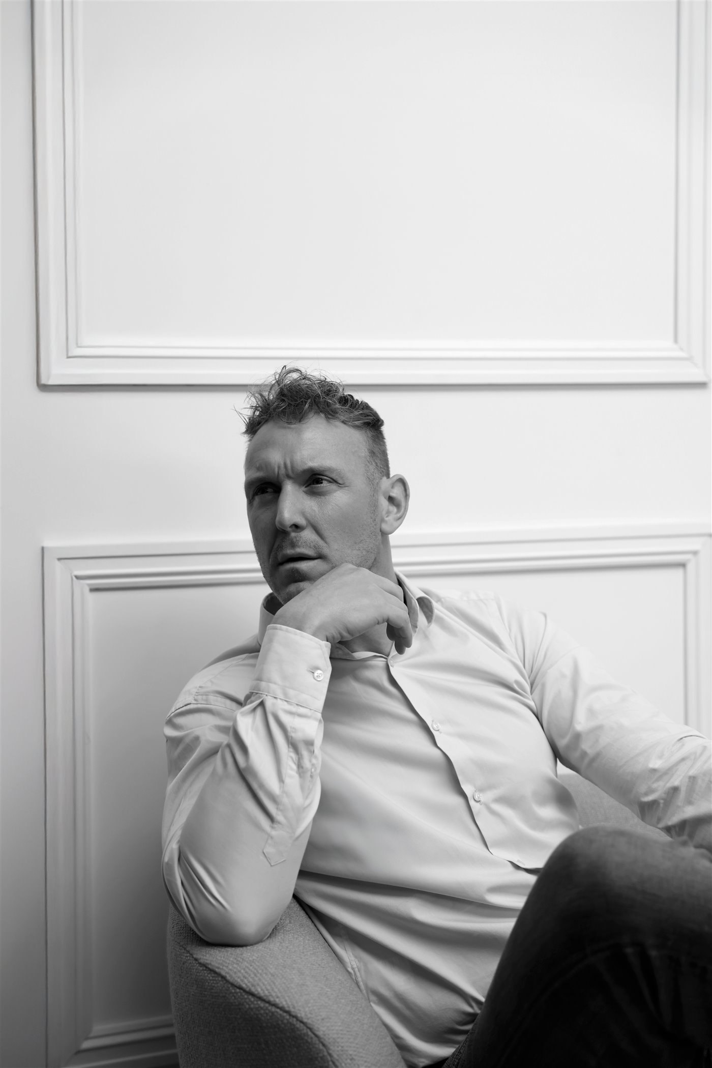 Jonathan Bouter zit nadenkend in een stoel, in zwart-wit
