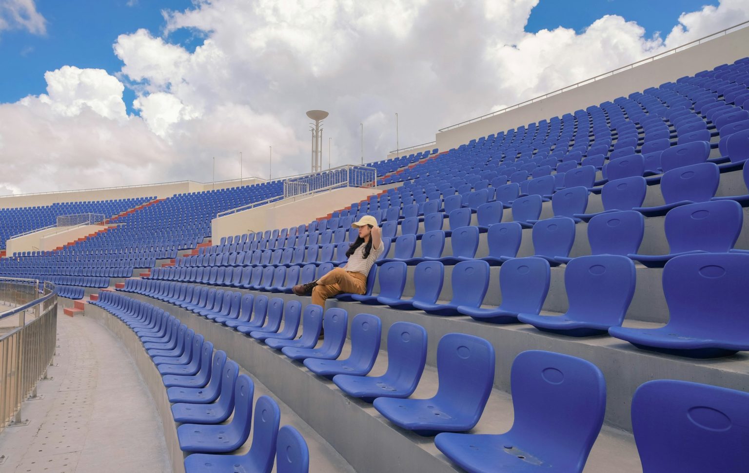 Vrouw zit alleen op de tribune van een leeg stadion