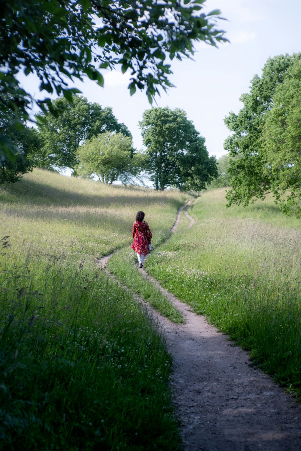 Vrouw loopt over een pad door een groen veld