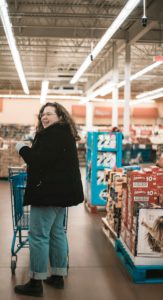 Lachende vrouw met een winkelwagen in de supermarkt