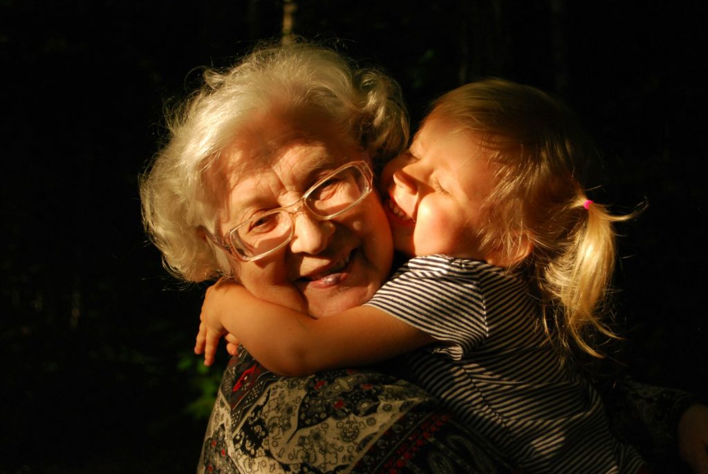 Oma en kleindochter omhelzen elkaar in warm avondlicht